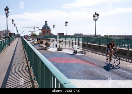 Personne sur un vélo sur le Pont Saint-Pierre, qui est fermé aux voitures en été sur la Garonne avec le dôme de l'hôpital la grave dans le b Banque D'Images