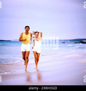 Jeune couple faisant du jogging sur une plage. Banque D'Images