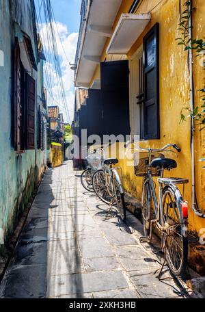 Vélos garés près du mur jaune, Hoi an (Hoian), Vietnam Banque D'Images