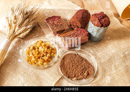 Muffins aux myrtilles, raisins secs et cacao sur toile avec épis de blé. Photo de haute qualité Banque D'Images