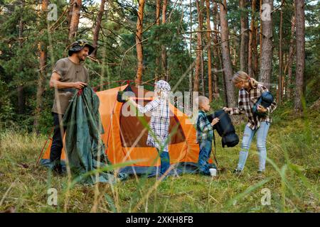 camping familial à la forêt. installation de tente. aventure en plein air avec les enfants Banque D'Images