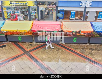 Le marché aux fruits s'étale sur Corporation Street un jour de pluie dans le centre commercial du centre-ville de Corby et Willow place. Banque D'Images