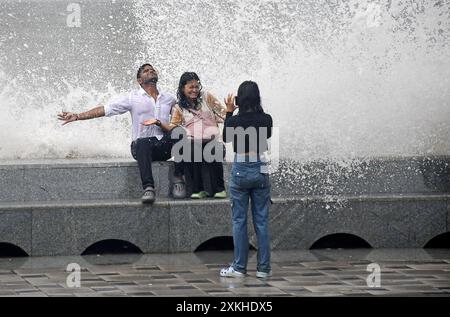 Mumbai, Maharashtra, Inde. 23 juillet 2024. Une femme prend des photos de ses amis sur la promenade de Marine Drive alors qu'ils profitent d'énormes vagues qui s'écrasent sur la route de la mer d'Arabie pendant la marée haute. Malgré le risque d'être emportés dans la mer, les gens affluent sur la promenade de Marine Drive pour profiter de la pluie et des énormes vagues qui s'écrasent sur la route de la mer d'Arabie ignorant l'avertissement de la Brihanmumbai Municipal Corporation (BMC) et de la police. (Crédit image : © Ashish Vaishnav/SOPA images via ZUMA Press Wire) USAGE ÉDITORIAL SEULEMENT! Non destiné à UN USAGE commercial ! Banque D'Images