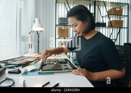 Ingénieur féminin réparant l'ordinateur dans l'atelier Banque D'Images