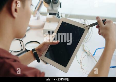 Homme réparant l'écran cassé dans l'atelier Banque D'Images