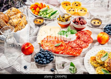 Pique-nique, hors-d'œuvre et plateau de fromage et de viande avec muffins sucrés et salés et fruits Banque D'Images