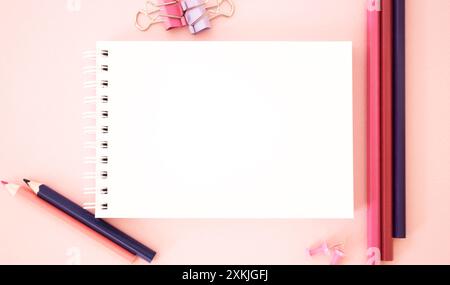Modèle. Fond rose avec des crayons. L'image montre espace libre pour le texte sur un carnet de notes sur fond rose. Image lumineuse. Image conceptuelle Banque D'Images
