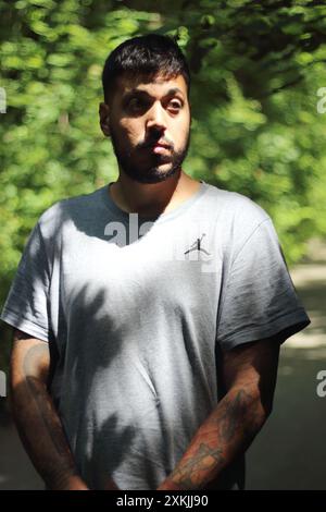 Une image vibrante représentant un jeune homme tatoué en vêtements de sport, profitant d'une journée ensoleillée dans la ville de Zurich. Parfait pour les thèmes liés à la Li urbaine Banque D'Images