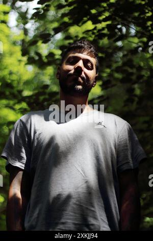 Une image vibrante représentant un jeune homme tatoué en vêtements de sport, profitant d'une journée ensoleillée dans la ville de Zurich. Parfait pour les thèmes liés à la Li urbaine Banque D'Images