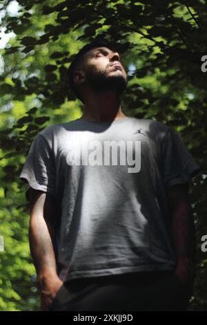 Une image vibrante représentant un jeune homme tatoué en vêtements de sport, profitant d'une journée ensoleillée dans la ville de Zurich. Parfait pour les thèmes liés à la Li urbaine Banque D'Images