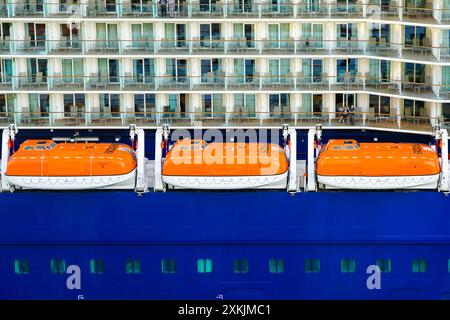 Barcelone, Espagne - 25 mai 2024 : fragment de vue latérale du navire de croisière Celebrity Equinox avec trois canots de sauvetage orange et balcons de cabines avec passagers Banque D'Images