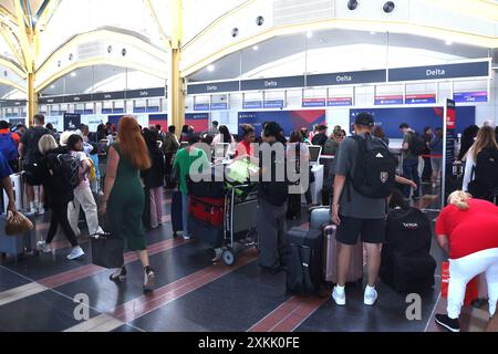 Arlington, Virginie, États-Unis. 23 juillet 2024. Vue de la porte Delta Air Lines à l'aéroport national Ronald Reagan Washington à Arlington, Virginie, avec des voyageurs qui font la queue pour leurs destinations après des vols annulés et retardés en raison d'une crise technologique massive le 23 juillet 2024. Crédit : Mpi34/Media Punch/Alamy Live News Banque D'Images