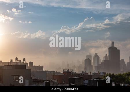 Lower Manhattan et les nuages sont éclairés par le soleil de l'après-midi vu d'un toit à Prospect Heights, Brooklyn, NY, USA. Banque D'Images