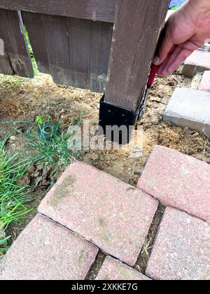 Réparation d'un poteau de clôture à l'aide d'outils et de finisseurs de briques Banque D'Images