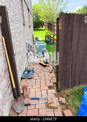 Réparation d'un poteau de clôture à l'aide d'outils et de finisseurs de briques Banque D'Images