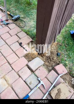 Réparation d'un poteau de clôture à l'aide d'outils et de finisseurs de briques Banque D'Images