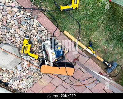 Réparation d'un poteau de clôture à l'aide d'outils et de finisseurs de briques Banque D'Images