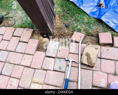 Réparation d'un poteau de clôture à l'aide d'outils et de finisseurs de briques Banque D'Images