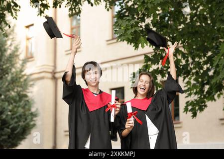 Heureux étudiants diplômés avec des diplômes en plein air Banque D'Images