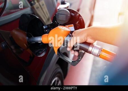 Homme conducteur main de remplissage et de pompage d'huile d'essence la voiture avec du carburant à la station de ravitaillement. Ravitaillement en carburant à la station-service. Pompe à carburant à la station. Réf Banque D'Images