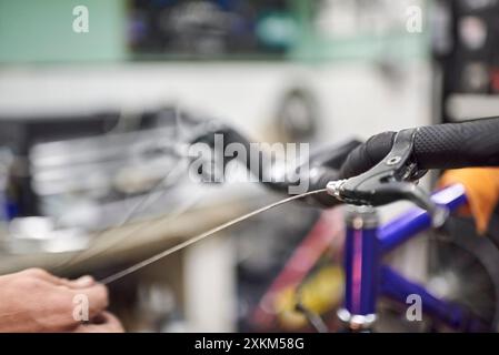 Réparateur méconnaissable assemblant le système de freinage d'un vélo dans le cadre du service d'entretien qu'il effectue dans son atelier. De vraies personnes au travail. Banque D'Images