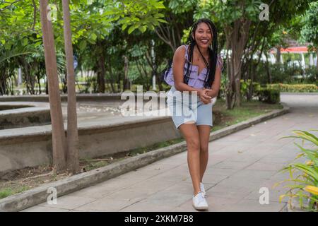 Jeune femme latina riant et posant à l'extérieur Banque D'Images