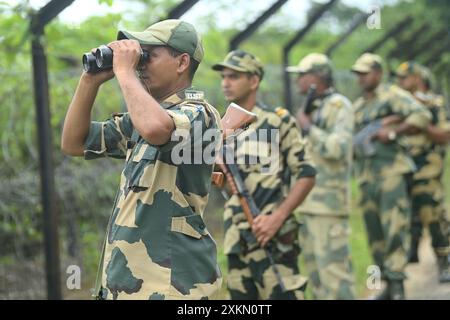 Des personnalités de sécurité de la Border Security Force (BSF) assurent une sécurité renforcée et patrouillent la clôture Inde-Bangladesh dans la région de Nischinta pur, en guise de précaution aux manifestations anti-quotas en cours dans le pays voisin, le Bangladesh. Agartala. Tripura, Inde. Banque D'Images