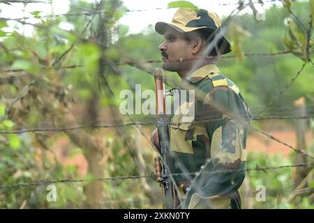 Des personnalités de sécurité de la Border Security Force (BSF) assurent une sécurité renforcée et patrouillent la clôture Inde-Bangladesh dans la région de Nischinta pur, en guise de précaution aux manifestations anti-quotas en cours dans le pays voisin, le Bangladesh. Agartala. Tripura, Inde. Banque D'Images