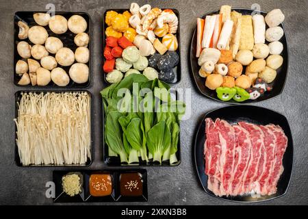 Une variété d'aliments sont exposés sur une table, y compris de la viande, des légumes et des fruits de mer. La présentation est colorée et appétissante, avec un mélange de Banque D'Images