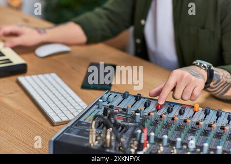 Un jeune homme dans un studio travaille sur un équipement de mixage audio. Banque D'Images