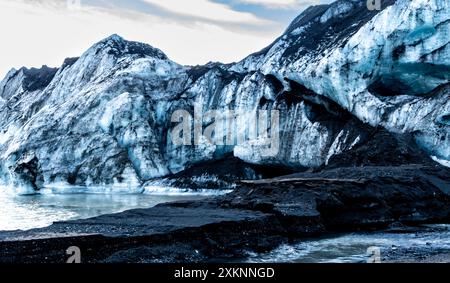 Glacier Solheimajokull, Islande. Une chaîne de montagnes de glace avec une grande masse d'eau devant elle. L'eau est gelée et les montagnes sont couvertes Banque D'Images