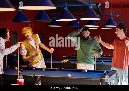 Les amis sont rassemblés autour d'une table de billard, riant et profitant d'une partie décontractée de billard. Banque D'Images