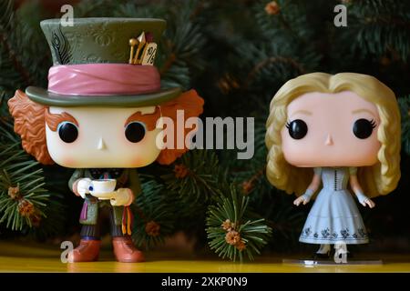 Funko Pop vinyle collection figurines d'action de Mad Hatter et Alice au pays des merveilles. Branches de sapin, sol jaune, Noël fabuleux et magique. Banque D'Images