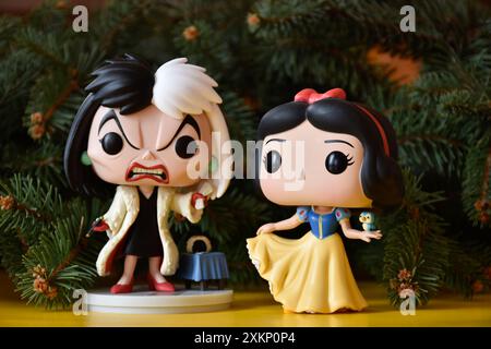 Funko Pop figurines d'action de Disney vilain Cruella de Vil du film d'animation 101 Dalmatiens et princesse Blanche-neige. Branches de sapin, sol jaune. Banque D'Images