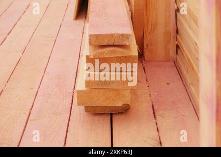 Les planches de bois sont empilées sur un chantier de construction. Planches en bois sur chantier. Construction d'une terrasse en bois. Banque D'Images