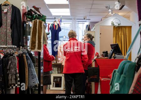 Des bénévoles discutent dans un magasin de charité Cornwall Air Ambulance à Newquay en Cornouailles au Royaume-Uni. Banque D'Images