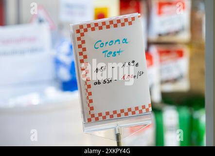 Munich, Allemagne. 24 juillet 2024. Un panneau portant les mots « test Corona » à l'entrée d'une pharmacie affiche les prix actuels des autotests. Crédit : Peter Kneffel/dpa/Alamy Live News Banque D'Images