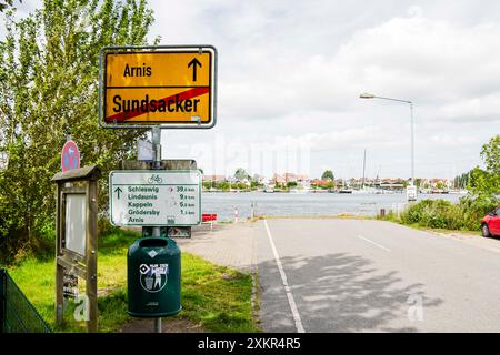 Sundsacker, Allemagne. 24 juillet 2024. Un panneau de ville se dresse sur le rivage. Le ferry qui relie la petite ville d'Arnis (district de Schleswig-Flensburg) à la rive sud du Schlei est hors service depuis deux ans. Selon le maire Matthiesen, la réparation du ferry coûterait 350 000 euros. Crédit : Frank Molter/dpa/Alamy Live News Banque D'Images