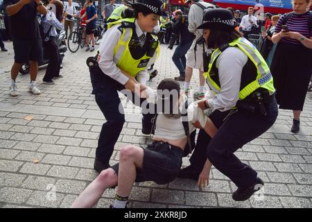 Londres, Royaume-Uni. 24 juillet 2024. Des policiers arrêtent un manifestant. Des manifestants pro-palestiniens se sont rassemblés devant le Bureau des Affaires étrangères, du Commonwealth et du développement à Westminster pour exiger un embargo sur les armes contre Israël alors que la guerre à Gaza se poursuit. Crédit : Vuk Valcic/Alamy Live News Banque D'Images