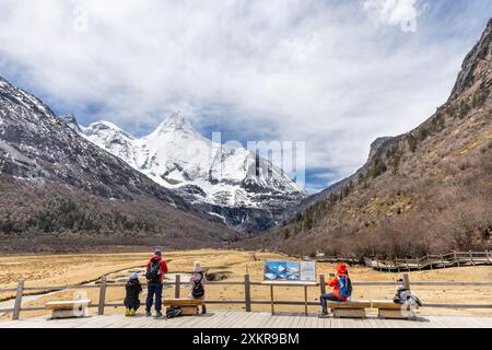 Randonneurs admirant le paysage à couper le souffle dans le pâturage de Luorong avec le mont Yangmaiyong comme toile de fond situé à la réserve naturelle de Yading, Garze Tibetan Banque D'Images