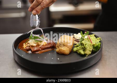 Oaxaca, Mexique. 23 juillet 2024. Un chef prépare des plats traditionnels dans un restaurant de la ville d'Oaxaca, capitale de l'État d'Oaxaca, au Mexique, le 23 juillet 2024. Oaxaca cuisine est une cuisine régionale du Mexique, centrée sur la ville d'Oaxaca. La nourriture traditionnelle telle que la sauce taupe, la sauterelle et la boisson Mezcal sont populaires parmi la population locale et les touristes. Crédit : Li Mengxin/Xinhua/Alamy Live News Banque D'Images