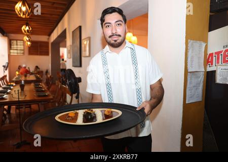 Oaxaca, Mexique. 23 juillet 2024. Un serveur présente des plats traditionnels avec de la sauce taupe dans un restaurant de la ville d'Oaxaca, capitale de l'État d'Oaxaca, au Mexique, le 23 juillet 2024. Oaxaca cuisine est une cuisine régionale du Mexique, centrée sur la ville d'Oaxaca. La nourriture traditionnelle telle que la sauce taupe, la sauterelle et la boisson Mezcal sont populaires parmi la population locale et les touristes. Crédit : Li Mengxin/Xinhua/Alamy Live News Banque D'Images