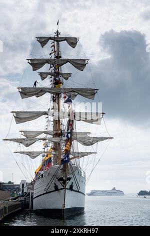 MARIEHAMN, Åland, FINLANDE - 24 JUILLET 2024 : le grand voilier Guayas de l'Équateur se trouve dans le port avec un marin debout sur un mât alors que le ferry de croisière Baltic Princess tourne autour pour accoster en arrière-plan. Premier jour des trois jours Åland Stage de la course de grands voiliers 2024 dans le port principal, Mariehamn, Åland, Finlande. Photo : Rob Watkins/Alamy Live News. INFO : la Tall Ships Race est un événement annuel de voile mettant en vedette des grands voiliers historiques et modernes. Il promeut l'amitié internationale et la formation des jeunes, attirant des participants et des spectateurs du monde entier pour célébrer le patrimoine maritime et l'art du trad Banque D'Images