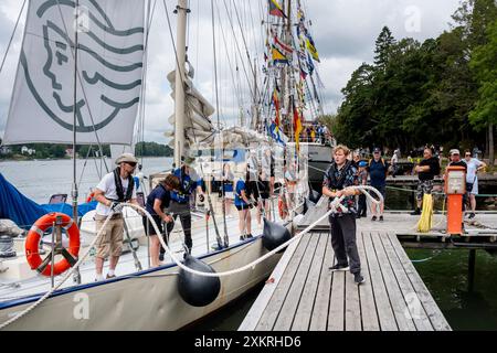 MARIEHAMN, Åland, FINLANDE - 24 JUILLET 2024 : les étudiants travaillent ensemble pour amarrer le grand voilier Helena. Premier jour des trois jours Åland Stage de la course de grands voiliers 2024 dans le port principal, Mariehamn, Åland, Finlande. Photo : Rob Watkins/Alamy Live News. INFO : la Tall Ships Race est un événement annuel de voile mettant en vedette des grands voiliers historiques et modernes. Il promeut l'amitié internationale et la formation des jeunes, attirant des participants et des spectateurs du monde entier pour célébrer le patrimoine maritime et l'art de la voile traditionnelle. Banque D'Images