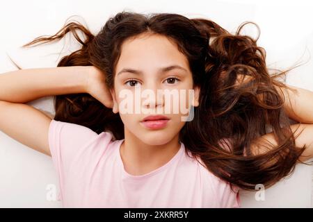 fille couchée sur le dos regardant la caméra avec une expression sérieuse Banque D'Images