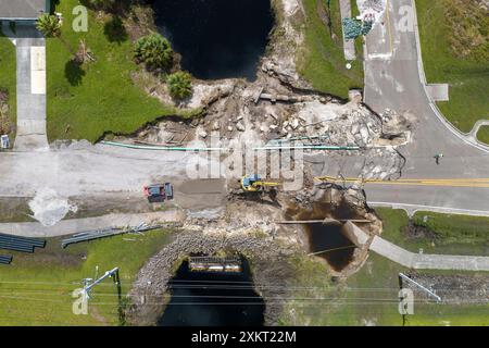 Construction de routes. Excavatrice réparant le pont détruit après que l'ouragan a inondé l'asphalte en Floride. Équipement de construction à Banque D'Images