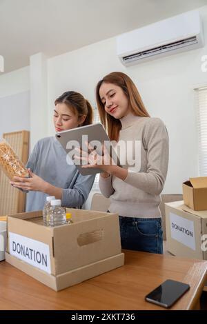 Jeune bénévole organisant des dons dans un centre communautaire pour les initiatives de charité et de soutien social Banque D'Images