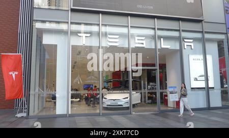 Shenzhen, Chine. 24 juillet 2024. Un piéton passe devant le magasin Tesla et le drapeau Tesla à Shenzhen, en Chine. (Photo de Serene Lee/SOPA images/SIPA USA) crédit : SIPA USA/Alamy Live News Banque D'Images