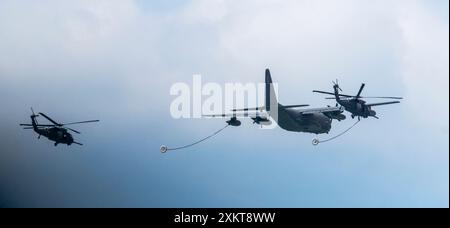 Jones Beach, New York, États-Unis - 29 mai 2022 : un gros avion cargo militaire vole en formation avec deux hélicoptères, l'un devant et l'autre Banque D'Images