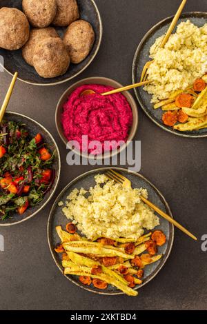 Profitez d'un copieux petit déjeuner ou déjeuner avec millet, courgettes cuites au four et carottes, accompagné d'une salade fraîche de légumes et d'herbes de saison, de petits pains aux pois chiches, Banque D'Images